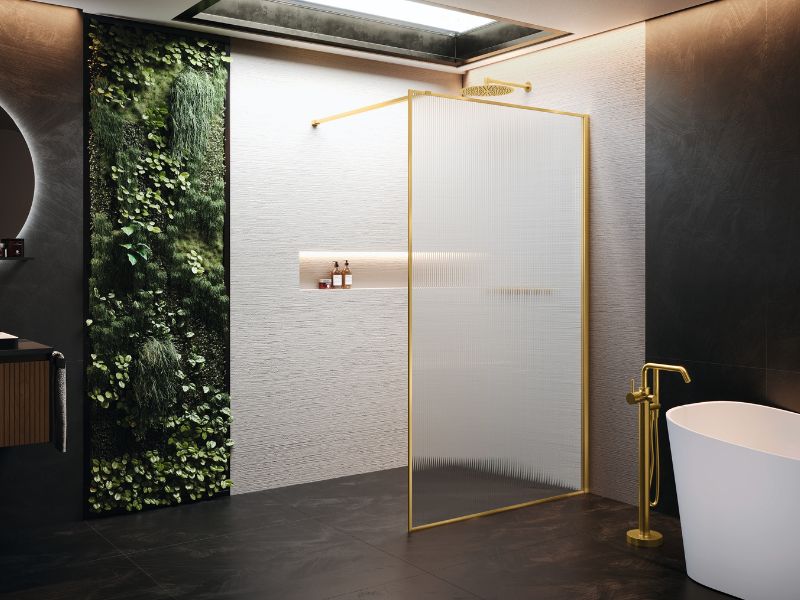 A luxury bathroom featuring a shower area and a bath area with fixtures in brushed gold.