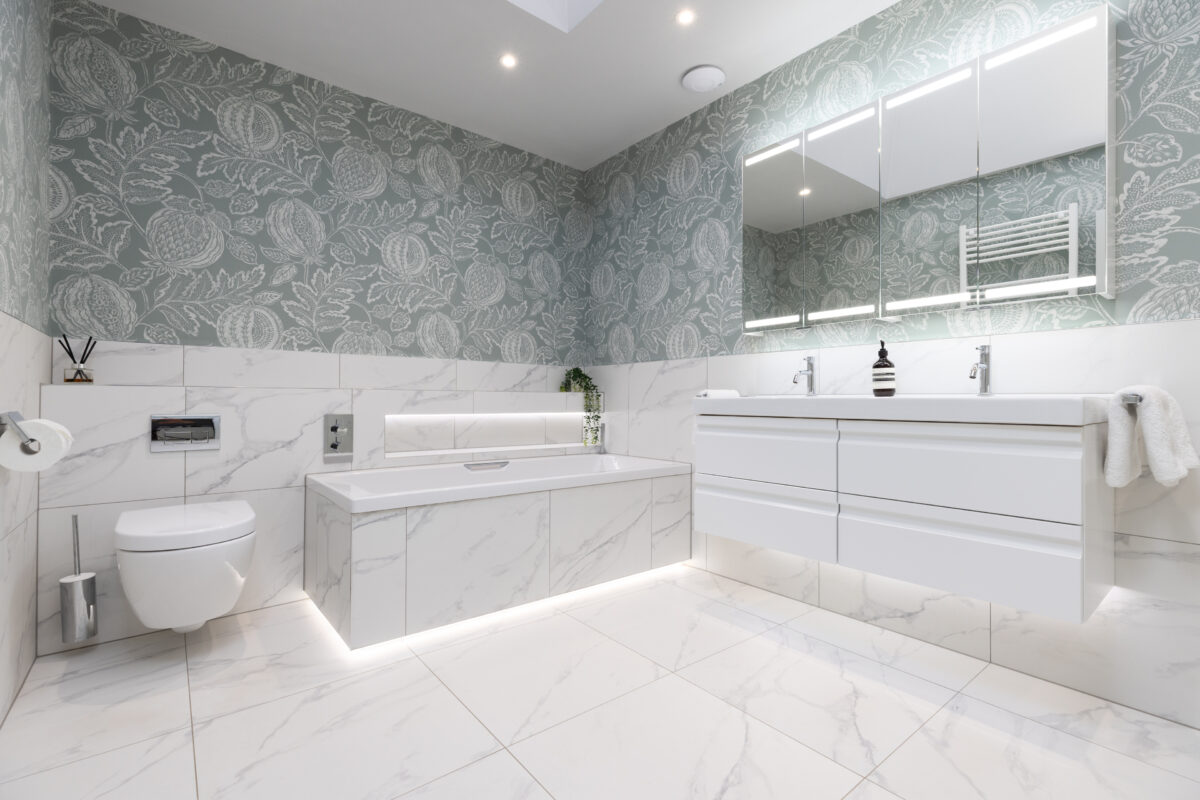 A modern bespoke bathroom renovation in Edinburgh featuring mirror cabinets, bath area, and vanity unit.