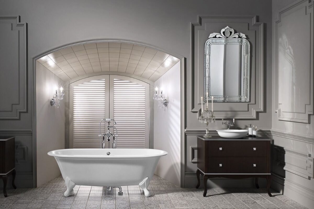 A classic bathroom features a free-standing white bath and a floor-mounted mixer, complemented by wood panelling in an off-whiteere is a vanity unit complete with a uniquely designed mirror. hue. At one end of the room, th